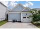 A detached two car garage with light blue siding, white garage doors, and plenty of parking space in the driveway at 1052 Avenue Of Oaks, Charleston, SC 29407