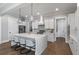 Stunning kitchen with white cabinets, stainless steel appliances, an island with seating, and modern lighting at 1052 Avenue Of Oaks, Charleston, SC 29407