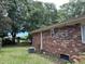 Backyard exterior showcasing the brick siding of the property and mature trees at 1056 Yorktown Dr, Charleston, SC 29412