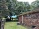 Home exterior displaying the backyard with brick siding and lush, green trees at 1056 Yorktown Dr, Charleston, SC 29412