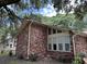 A close-up of a beautiful brick home featuring stylish windows that add character and charm to the property at 1056 Yorktown Dr, Charleston, SC 29412