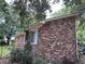 Side view of a brick home with partial fencing, accented by green plants and a tree providing some shade at 1056 Yorktown Dr, Charleston, SC 29412