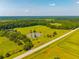 Aerial view showcasing a property with a pond, surrounded by lush greenery and a road at 1133 Highway 311, Cross, SC 29436