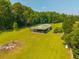 Aerial view showcasing barn with grazing area and lush green pasture land surrounded by trees at 1133 Highway 311, Cross, SC 29436