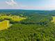 Aerial view showcasing lush greenery, open fields, and a distant body of water at 1133 Highway 311, Cross, SC 29436