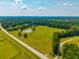 Wide aerial view of land featuring a pond, lush greenery, and a long straight road at 1133 Highway 311, Cross, SC 29436