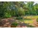 Lush backyard featuring mature trees, a wooden fence, and a tranquil seating area at 1133 Highway 311, Cross, SC 29436