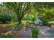 Lush backyard featuring a brick patio, charming seating area, and mature trees providing ample shade at 1133 Highway 311, Cross, SC 29436