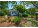 Quaint home exterior with a lush garden and inviting entrance with mature trees at 1133 Highway 311, Cross, SC 29436