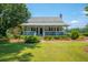 Charming cottage-style home with a manicured front lawn and classic architectural details at 1133 Highway 311, Cross, SC 29436