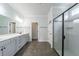 Modern bathroom featuring double vanity, framed mirrors, tiled floors, and a glass-enclosed shower with tiled walls at 1250 Hammrick Ln, Johns Island, SC 29455