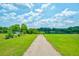 Scenic view of lush green lawn and lake, with a path leading to a relaxing and picturesque outdoor space at 1250 Hammrick Ln, Johns Island, SC 29455