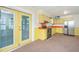 Cozy kitchen with yellow cabinets, stainless steel refrigerator, and access to the sunroom at 127 Rahway Rd, Goose Creek, SC 29445