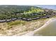 Beautiful aerial view of beachside condos near golf course, lush trees, and sandy shoreline at 1334 Pelican Watch Villas, Seabrook Island, SC 29455