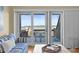 Bright living room featuring stylish blue striped couch and sliding glass doors with water view at 1334 Pelican Watch Villas, Seabrook Island, SC 29455