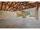 Spacious garage featuring exposed wooden beams, concrete floor, and an open layout leading to the outdoors at 1430 E Montague Ave, North Charleston, SC 29405
