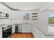 Updated kitchen with stainless steel appliances, light cabinets, granite countertops, and wood floors at 1430 E Montague Ave, North Charleston, SC 29405
