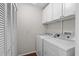 Functional laundry room equipped with a washer, dryer, and ample storage cabinets at 146 High Hammock Villas, Seabrook Island, SC 29455