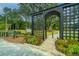 Beautiful community entrance with a black arbor, lush landscaping, and paved pathway at 1529 Foster Creek Rd, Hanahan, SC 29410