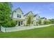 Charming modern farmhouse with white siding, blue door, green lawn and white picket fence at 1529 Foster Creek Rd, Hanahan, SC 29410