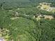 A wide aerial view shows a lush forest with trees, highlighting the natural surroundings of the property at 153 Willow Brook Way, Cordesville, SC 29434