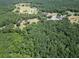A wide aerial view shows a lush forest with trees and homes, highlighting the natural surroundings of the property at 153 Willow Brook Way, Cordesville, SC 29434
