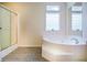 Bathroom featuring tiled floors, glass-door shower, large jacuzzi tub, and window at 153 Willow Brook Way, Cordesville, SC 29434