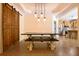 Open dining area with rustic wood table and industrial pendant lighting, flowing into the kitchen and a sliding barn door at 153 Willow Brook Way, Cordesville, SC 29434