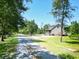 Charming home featuring a welcoming screened-in porch, inviting deck, and a serene gravel driveway at 153 Willow Brook Way, Cordesville, SC 29434