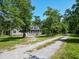 Inviting home with screened porch along a gravel road, surrounded by trees at 153 Willow Brook Way, Cordesville, SC 29434
