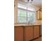 The kitchen sink sits in front of a large window with wooden cabinets underneath at 153 Willow Brook Way, Cordesville, SC 29434