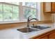 Stainless kitchen sink with faucet beneath a window and neutral colored countertops at 153 Willow Brook Way, Cordesville, SC 29434