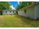 Backyard with healthy grass, a small patio, and house painted neutral at 1612 Evergreen St, Charleston, SC 29407
