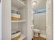 Bathroom featuring built-in linen storage next to a toilet and shower with curtains at 1617 Refuge Run, Charleston, SC 29412