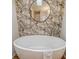 Close up of a soaking tub with stylish faucets and a round mirror reflecting the bathroom skylight at 1617 Refuge Run, Charleston, SC 29412