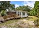 A charming two-story brick home with a wooden wheelchair ramp surrounded by mature trees at 1789 Balfoure Dr, Charleston, SC 29407