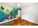 This bedroom features hardwood floors, a ceiling fan, and playful wall art for a creative space at 1789 Balfoure Dr, Charleston, SC 29407