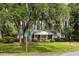 View of brick home with moss draped trees on a large grassy lawn at the corner of two streets at 1789 Balfoure Dr, Charleston, SC 29407