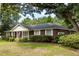Brick home with white trim features neatly manicured landscaping on a large lawn at 1789 Balfoure Dr, Charleston, SC 29407
