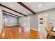 Spacious living room with hardwood floors, exposed beams and views of the sunroom and dining area at 1789 Balfoure Dr, Charleston, SC 29407
