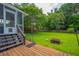 A well-maintained backyard featuring a wooden deck, green lawn, and a fire pit at 2005 Thornhill Dr, Summerville, SC 29485
