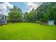 Expansive backyard with lush lawn, mature trees, a shed, and a wooden fence at 2005 Thornhill Dr, Summerville, SC 29485