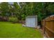 Backyard storage shed in a well-manicured lawn surrounded by trees and fencing at 2005 Thornhill Dr, Summerville, SC 29485