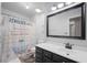 A well-lit bathroom features modern fixtures, a decorative shower curtain, and a large mirror at 2005 Thornhill Dr, Summerville, SC 29485