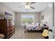 A cozy bedroom featuring a ceiling fan, window with blinds, and furniture including a dresser and bedside table at 2005 Thornhill Dr, Summerville, SC 29485