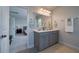 Bright bathroom with double vanity, gray cabinets, and a view to an adjacent bedroom at 2017 Geranium Ln, Johns Island, SC 29455