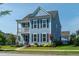 Charming two-story home with light blue siding, black shutters, and a quaint second-story porch at 2017 Geranium Ln, Johns Island, SC 29455