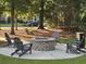 Cozy brick fire pit area with Adirondack chairs, perfect for gathering and relaxation in a landscaped setting at 2017 Geranium Ln, Johns Island, SC 29455