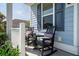 Inviting covered porch with rocking chairs, tasteful plants, and blue painted siding at 2017 Geranium Ln, Johns Island, SC 29455