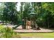 Inviting community playground with slides, climbing structures, and swings surrounded by lush greenery and trees at 2017 Geranium Ln, Johns Island, SC 29455